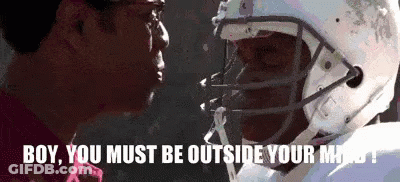 A Football Player Wearing A Helmet Is Talking To Another Man . GIF