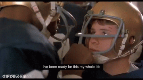 A Football Player Wearing A Helmet Is Talking To Another Player . GIF
