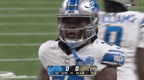 A Football Player Wearing A Helmet Stands On A Field With A Scoreboard Displaying The Score Of 0 To 39 GIF