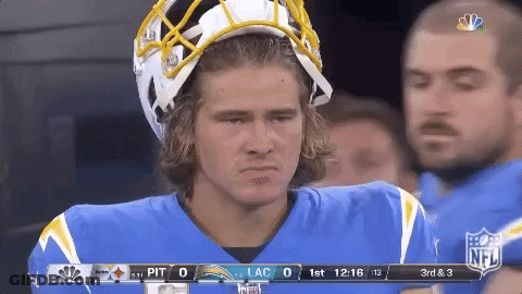 A Football Player Wearing A Helmet Stands On The Sidelines GIF
