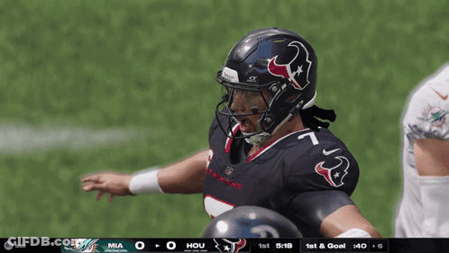 A Football Player Wearing A Helmet With A Bull On It Stands On The Field GIF