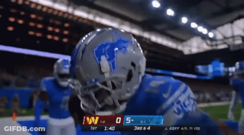 A Football Player Wearing A Helmet With A Lion On It Stands On The Field GIF