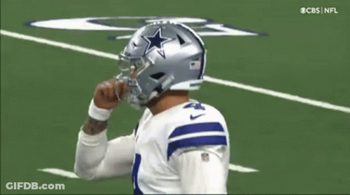 A Football Player Wearing A Helmet With A Star On It Is On The Field . GIF