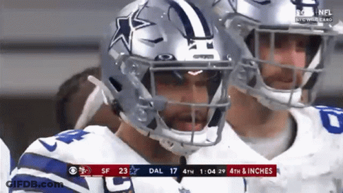 A Football Player Wearing A Helmet With A Star On It Is Standing Next To Another Player . GIF