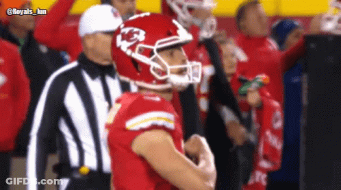 A Football Player Wearing A Helmet With The Letter K On It Stands Next To A Referee GIF