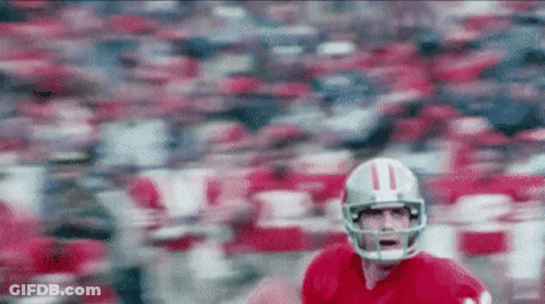 A Football Player Wearing A Helmet With The Number 11 On It Is Running On A Field GIF