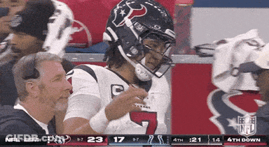 A Football Player Wearing A Helmet With The Number 7 On It Stands In The Stands GIF