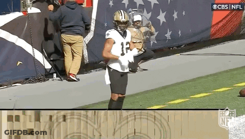 A Football Player Wearing A Jersey With The Number 12 On It Is Standing On The Field . GIF
