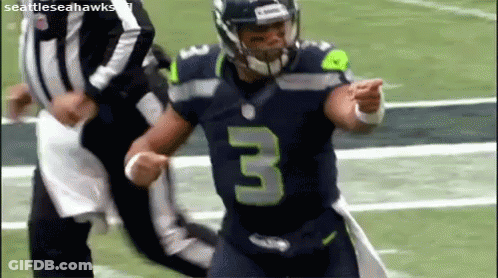 A Football Player Wearing A Jersey With The Number 3 On It Is Running On A Field . GIF