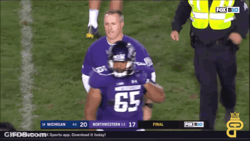 A Football Player Wearing A Jersey With The Number 65 GIF