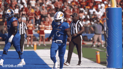 A Football Player Wearing A Kansas Uniform Runs Towards The Goal Line GIF