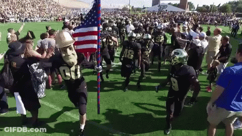 A Football Player Wearing A Mask With The Number 00 On It Is Holding An American Flag GIF
