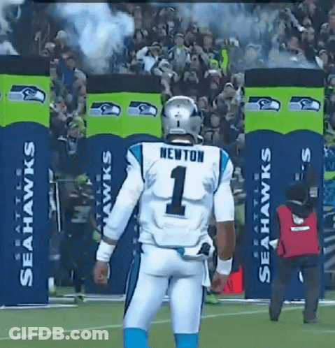 A Football Player Wearing A Number 1 Jersey Stands In Front Of Seahawks Banners GIF