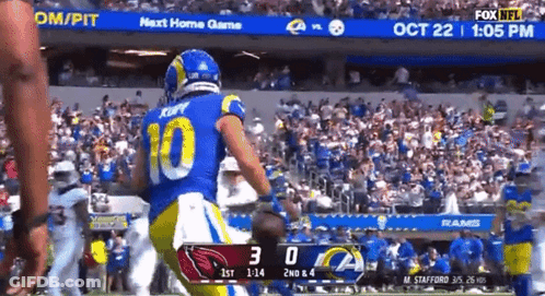 A Football Player Wearing A Number 10 Jersey Is Running On A Field GIF