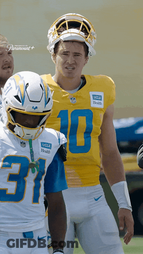 A Football Player Wearing A Number 10 Jersey Stands Next To Another Player Wearing A Number 37 Jersey GIF