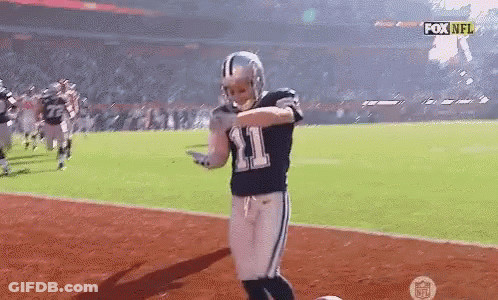 A Football Player Wearing A Number 11 Jersey Is Dancing On The Field . GIF