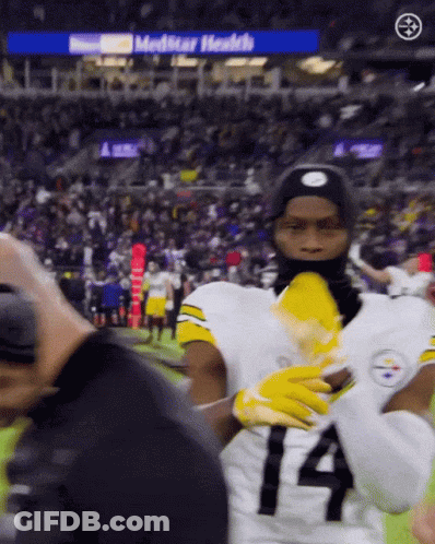 A Football Player Wearing A Number 14 Jersey Stands On The Field GIF