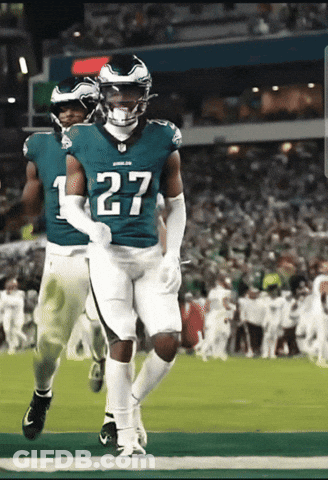 A Football Player Wearing A Number 27 Jersey Is Running On The Field GIF