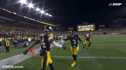 A Football Player Wearing A Number 3 Jersey Holds Hands With Another Player GIF