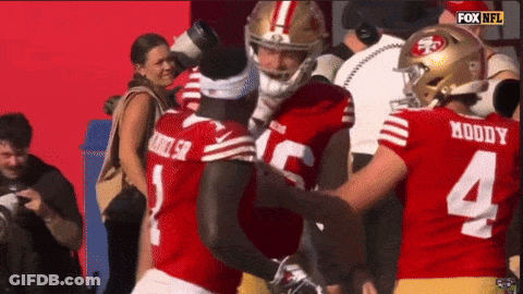 A Football Player Wearing A Number 4 Jersey Is Hugging Another Player GIF