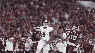 A Football Player Wearing A Number 4 Jersey Is Running With The Ball GIF