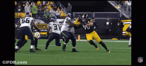 A Football Player Wearing A Number 40 Jersey Is Being Tackled By Another Player GIF