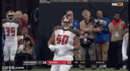 A Football Player Wearing A Number 50 Jersey Is Running On The Field GIF