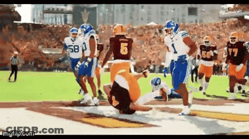A Football Player Wearing A Number 6 Jersey Is Being Tackled By Another Player GIF
