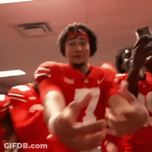 A Football Player Wearing A Number 7 Jersey Is Hugging Another Player . GIF