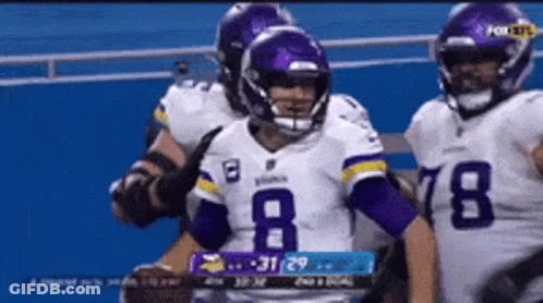 A Football Player Wearing A Number 8 Jersey Is Standing Next To Another Player . GIF
