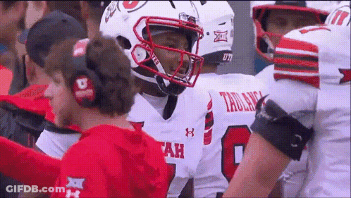 A Football Player Wearing A Number 8 Jersey Talks To A Coach GIF