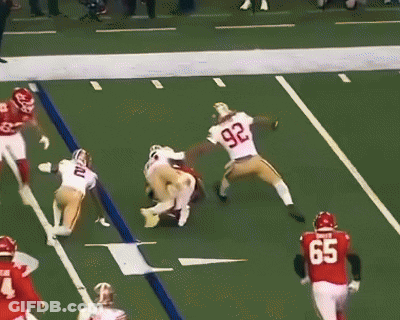 A Football Player Wearing A Number 97 Jersey Is Being Tackled By Another Player GIF