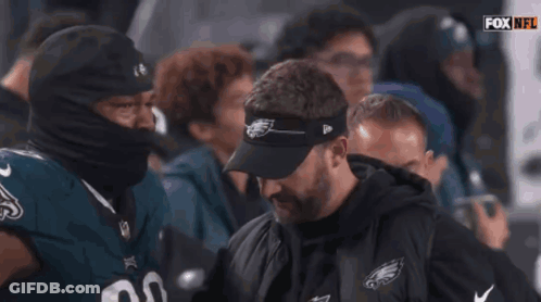 A Football Player Wearing A Number 98 Jersey Talks To A Coach GIF