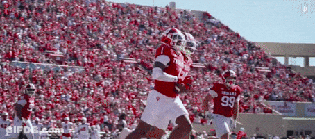 A Football Player Wearing A Number 99 Jersey Runs With The Ball GIF