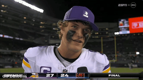 A Football Player Wearing A Purple Hat And A Jersey With The Letter C On It GIF