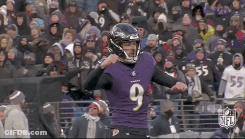 A Football Player Wearing A Purple Jersey And A Black Helmet Is Standing In Front Of A Crowd . GIF