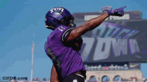 A Football Player Wearing A Purple Jersey With Tcu On The Front GIF