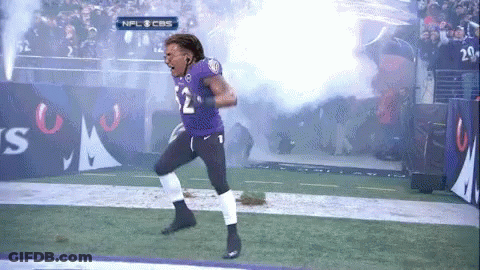 A Football Player Wearing A Purple Jersey With The Number 12 On It GIF