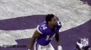 A Football Player Wearing A Purple Jersey With The Number 14 On It Is Jumping In The Air . GIF