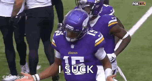 A Football Player Wearing A Purple Vikings Jersey Is Standing On A Field With His Arms Outstretched . GIF