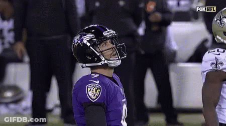 A Football Player Wearing A Ravens Jersey Looks Up At The Sky . GIF