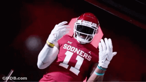 A Football Player Wearing A Red Jersey With The Number 11 On It Is Standing In A Tunnel . GIF