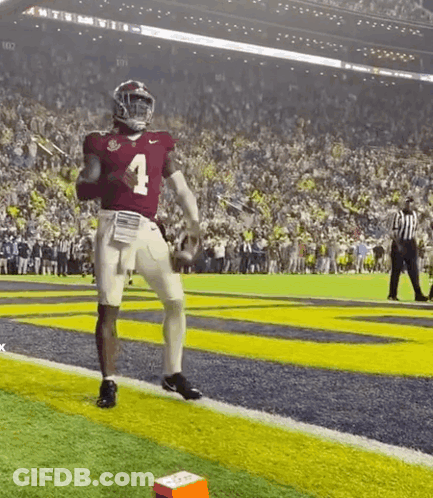 A Football Player Wearing A Red Jersey With The Number 4 On It Is Running On The Field . GIF