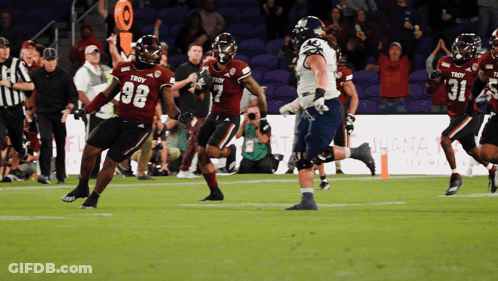 A Football Player Wearing A Troy Jersey Runs With The Ball GIF