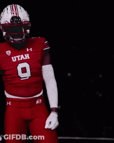 A Football Player Wearing A Utah Uniform Is Pointing At Something GIF