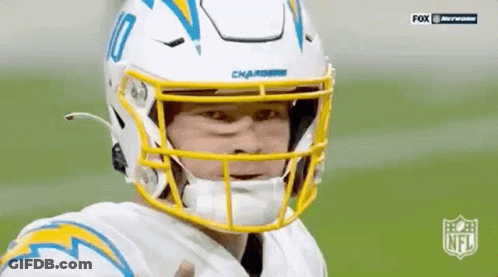 A Football Player Wearing A White Helmet And A Yellow Visor Is Giving A Thumbs Up . GIF