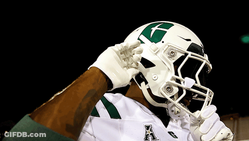 A Football Player Wearing A White Helmet With A Green X On It GIF