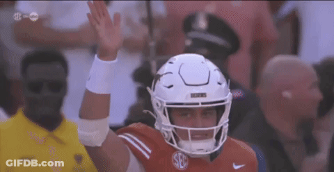 A Football Player Wearing A White Helmet With The Letter S On It GIF