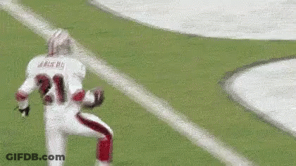A Football Player Wearing A White Jersey With The Number 21 On It Is Running On The Field . GIF