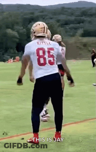 A Football Player Wearing A White Jersey With The Number 85 Is Standing On A Field . GIF